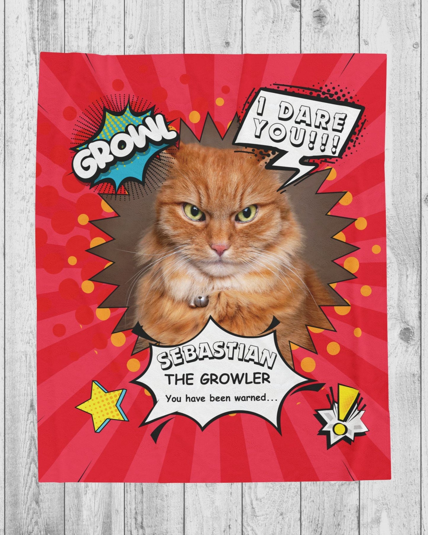 Flat lay of personalized comic-style cat blanket featuring an orange tabby named Sebastian with speech bubbles and a red background on a wood floor