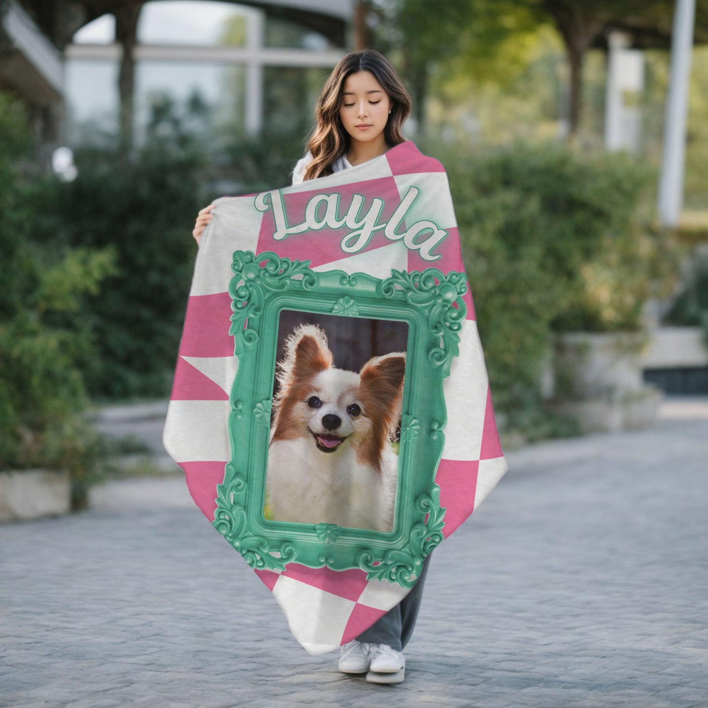 Personalized dog blanket with photo and name Layla, pink checkered pattern and teal frame, shown outdoors with woman holding it