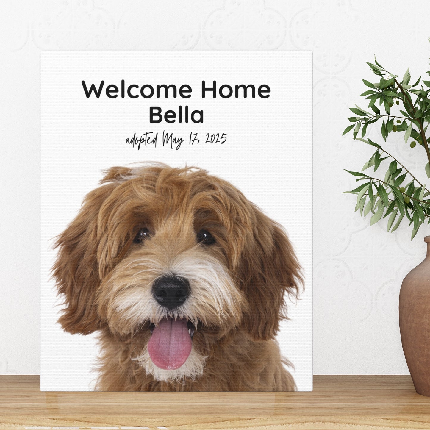 Personalized 8x10 dog adoption canvas print featuring Bella the doodle, displayed on a wooden surface with a potted plant in a brown vase.