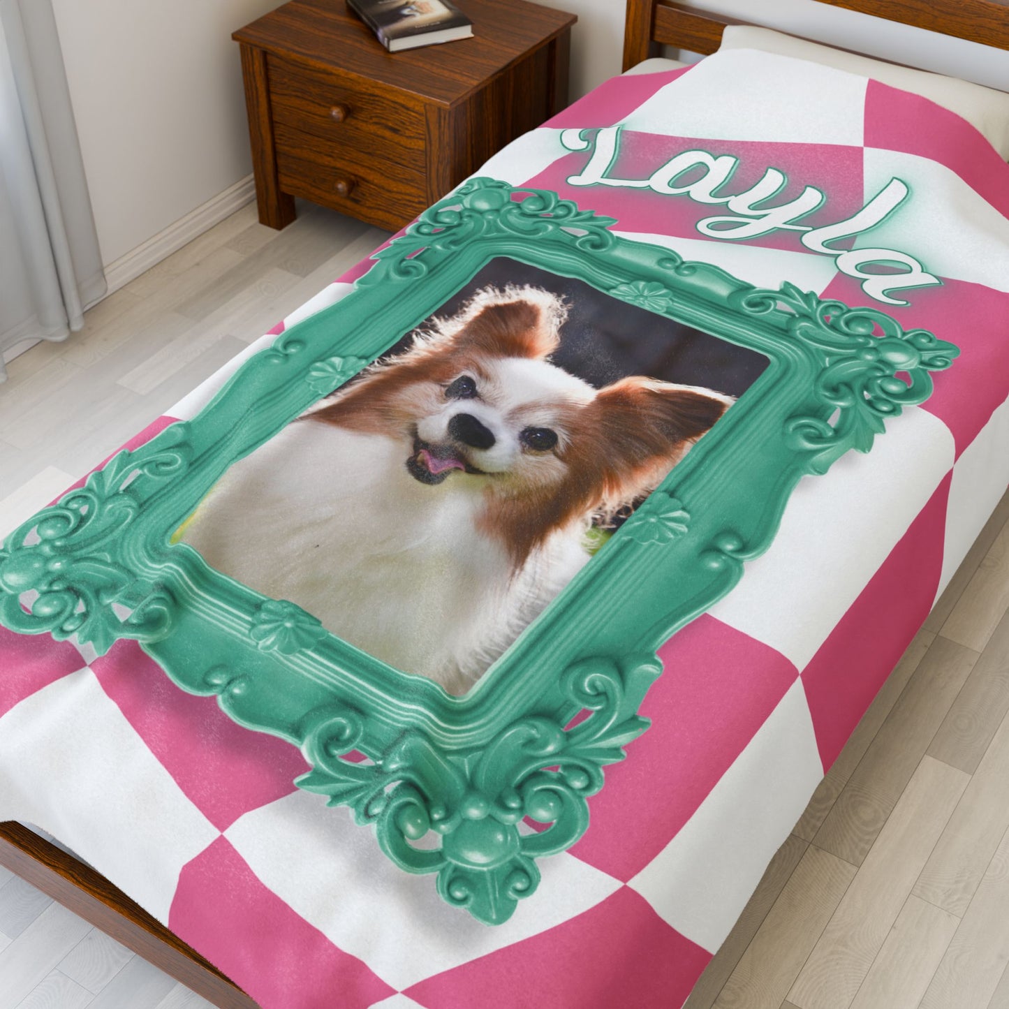 Personalized dog photo blanket with teal frame and name Layla shown on bed with pink and white checkered design