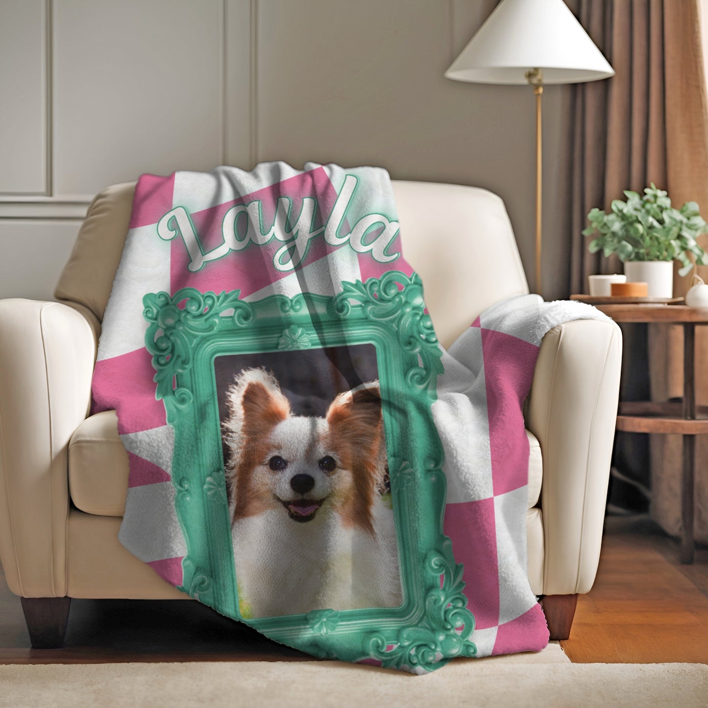 Custom dog photo blanket with pink and white checkered design, teal frame, and name Layla draped over armchair in cozy living room