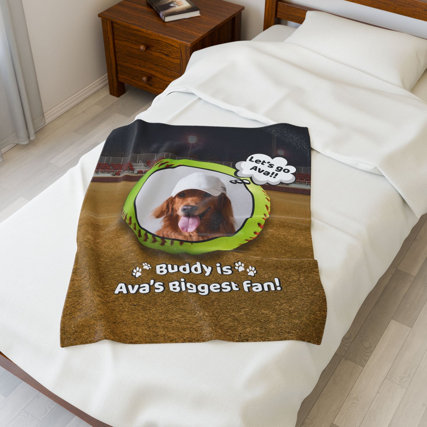 Small personalized softball dog blanket featuring Buddy with “Buddy is Ava's Biggest Fan” message, shown on a white bed; ideal size for babies or puppies