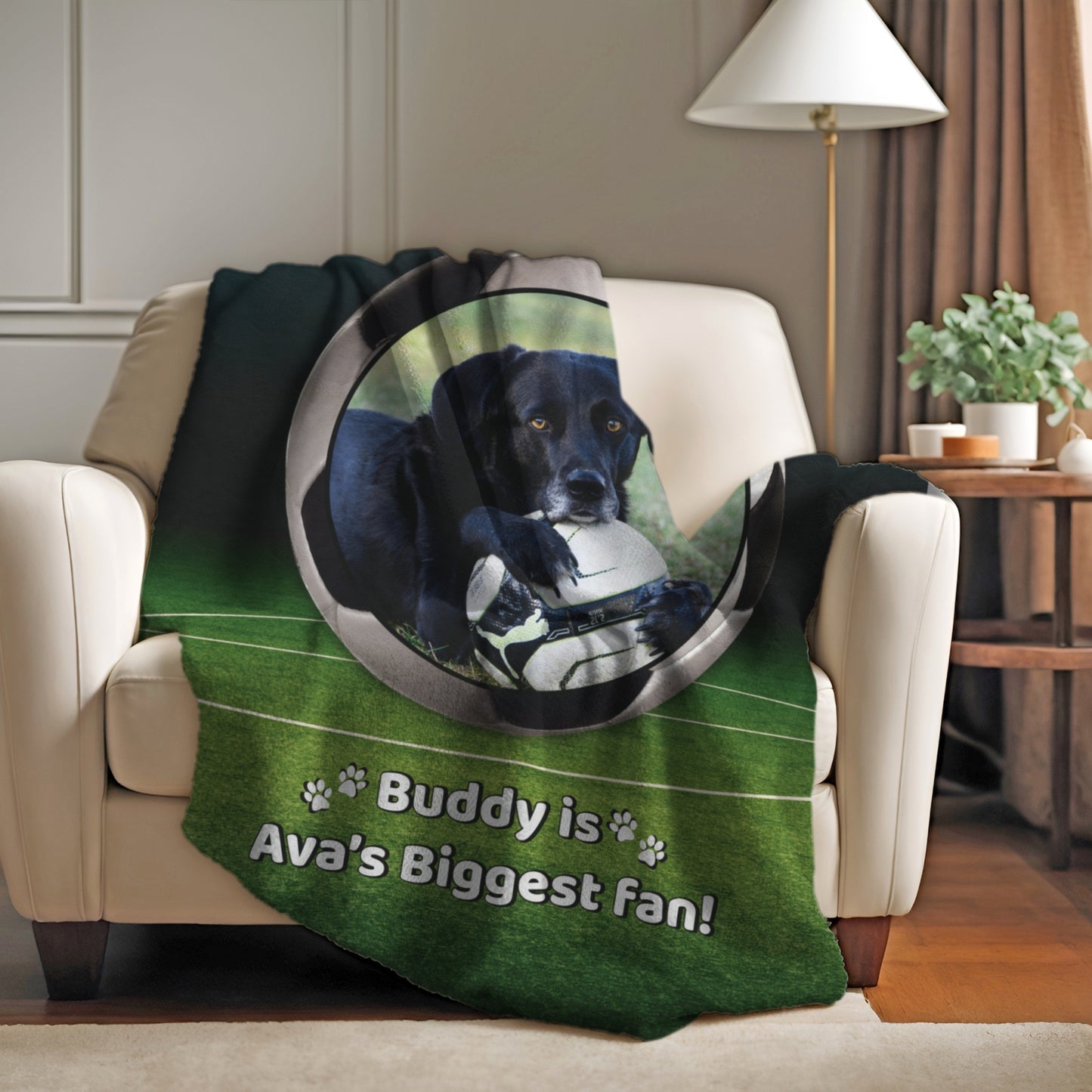Personalized soccer dog blanket with Buddy and “Ava’s Biggest Fan” message, draped on a white armchair in a cozy home setting