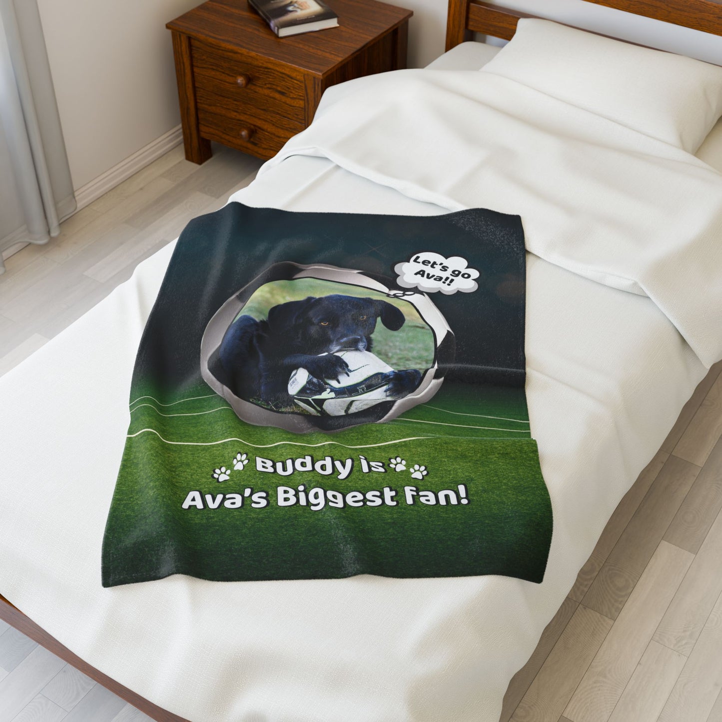Small personalized soccer dog blanket featuring Buddy and “Ava’s Biggest Fan” message, displayed on a bed to suggest baby or pet use