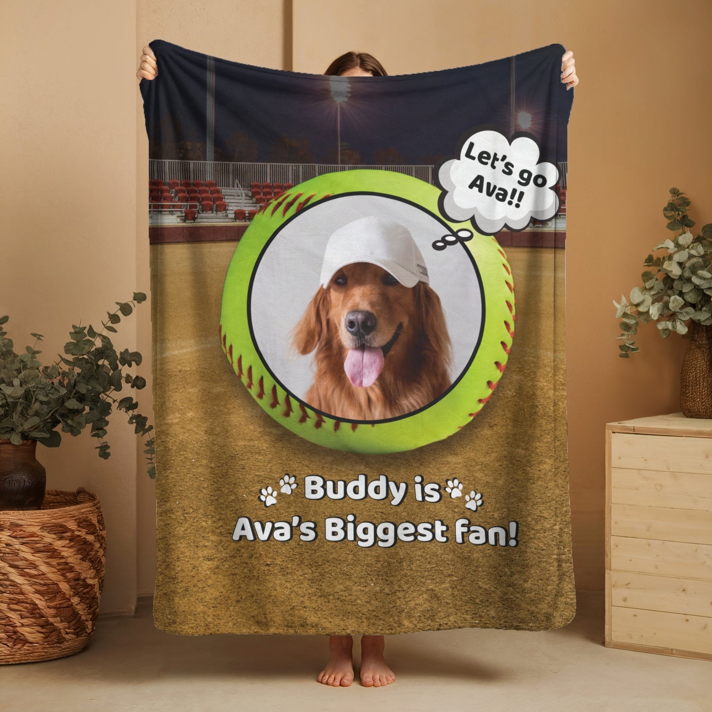 Personalized softball dog blanket featuring Buddy and “Buddy is Ava’s Biggest Fan” message, shown being held up in a cozy home setting to display full design and size
