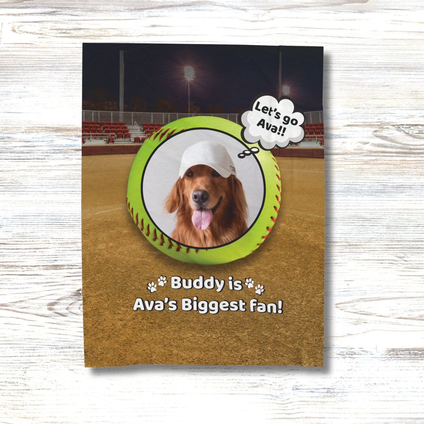 Softball-themed personalized dog blanket featuring Buddy with text "Buddy is Ava's Biggest Fan" on a ballpark background, displayed on a white wood surface