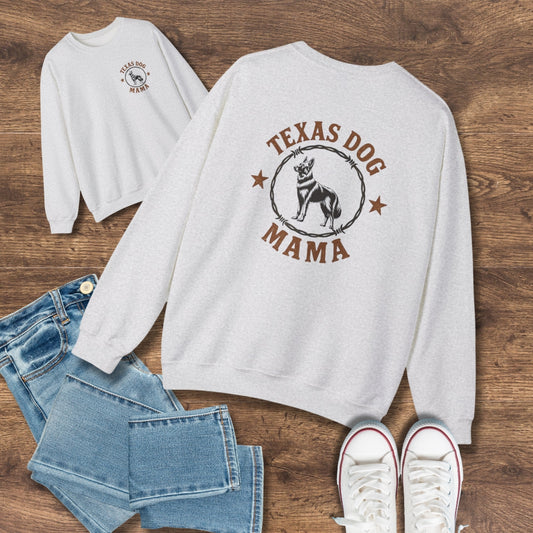 Flat lay of gray Texas Dog Mama German Shepherd sweatshirt with rustic barbed wire design, styled with jeans and sneakers on wood.
