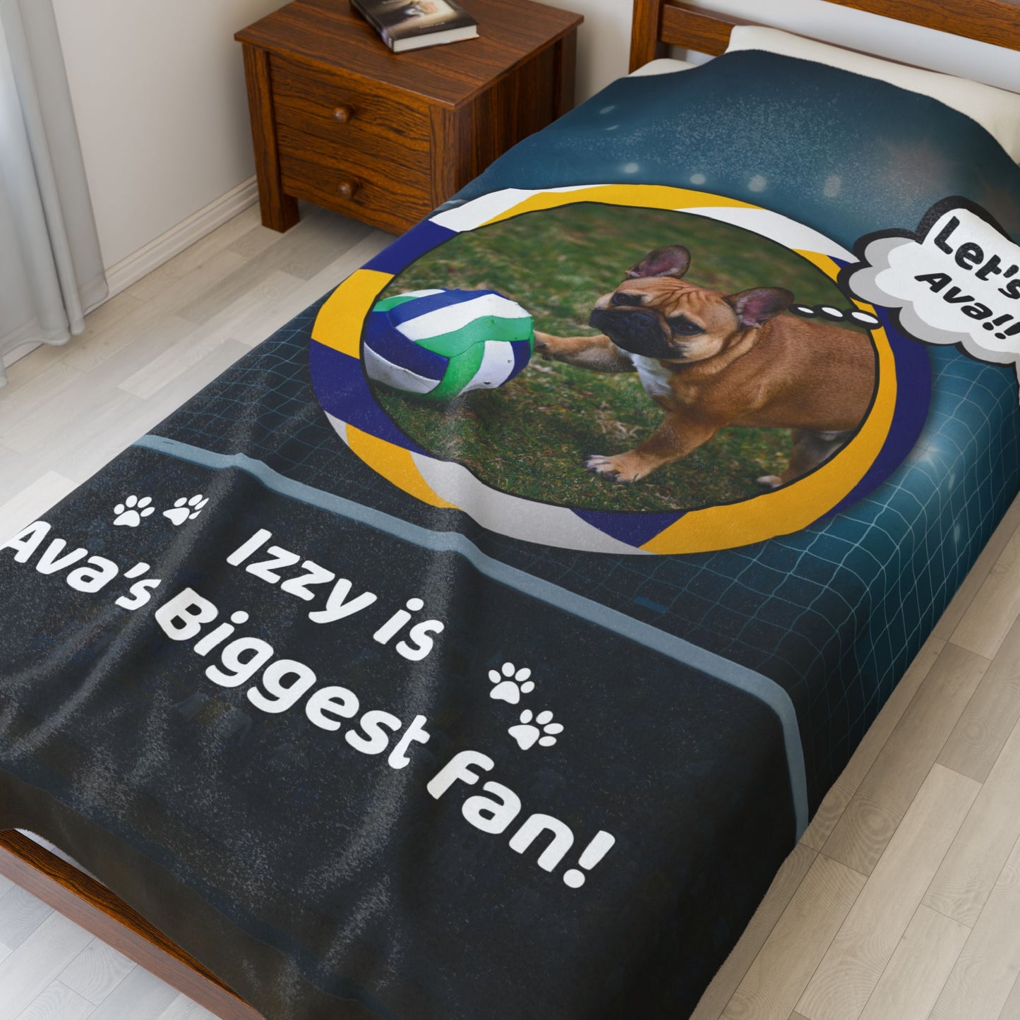 Large personalized volleyball dog blanket featuring Izzy the French Bulldog, styled on a neatly made bed with wood furniture.