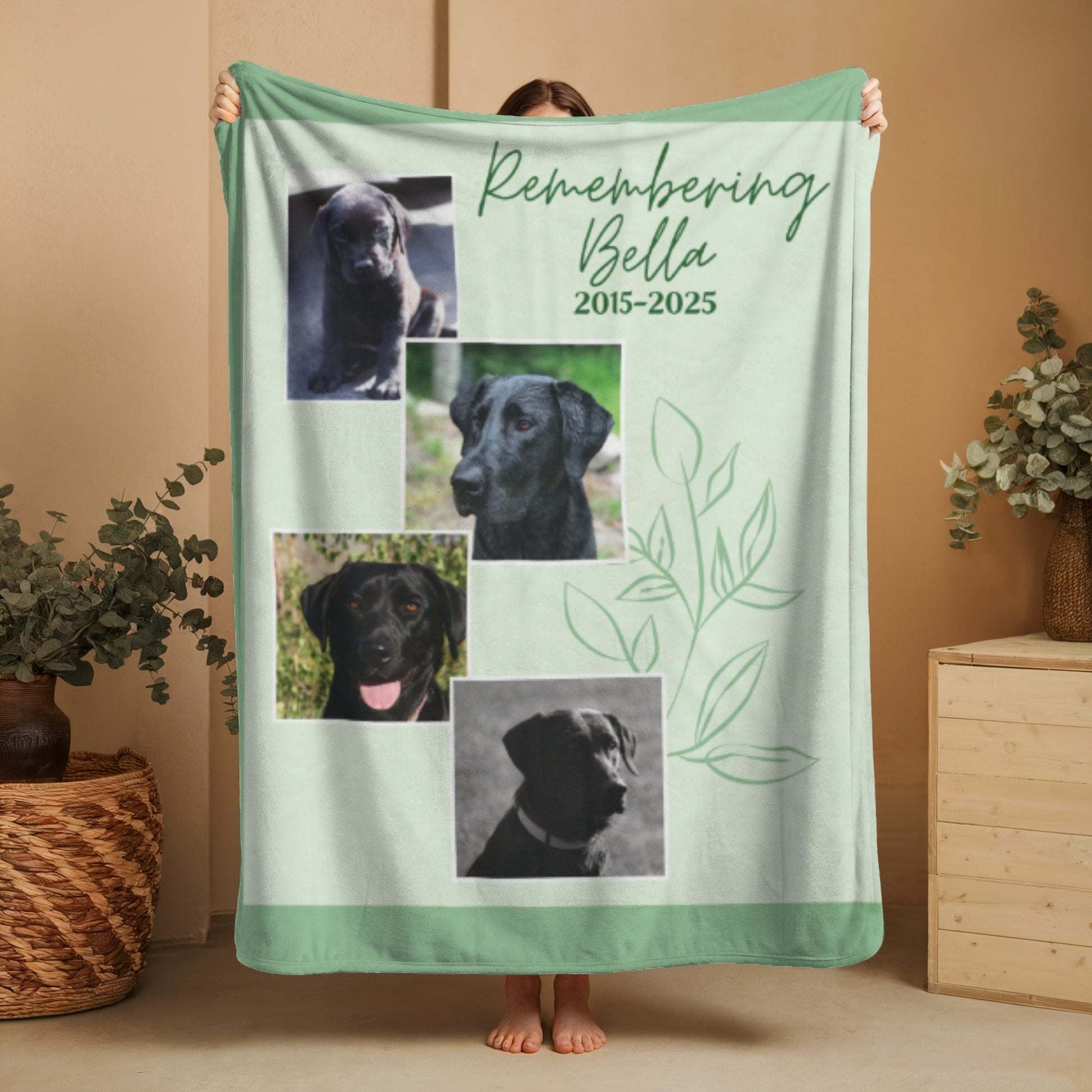 Woman holding Spring Meadow green memorial blanket with four dog photos, leaf design, and "Remembering Bella 2015–2025" message