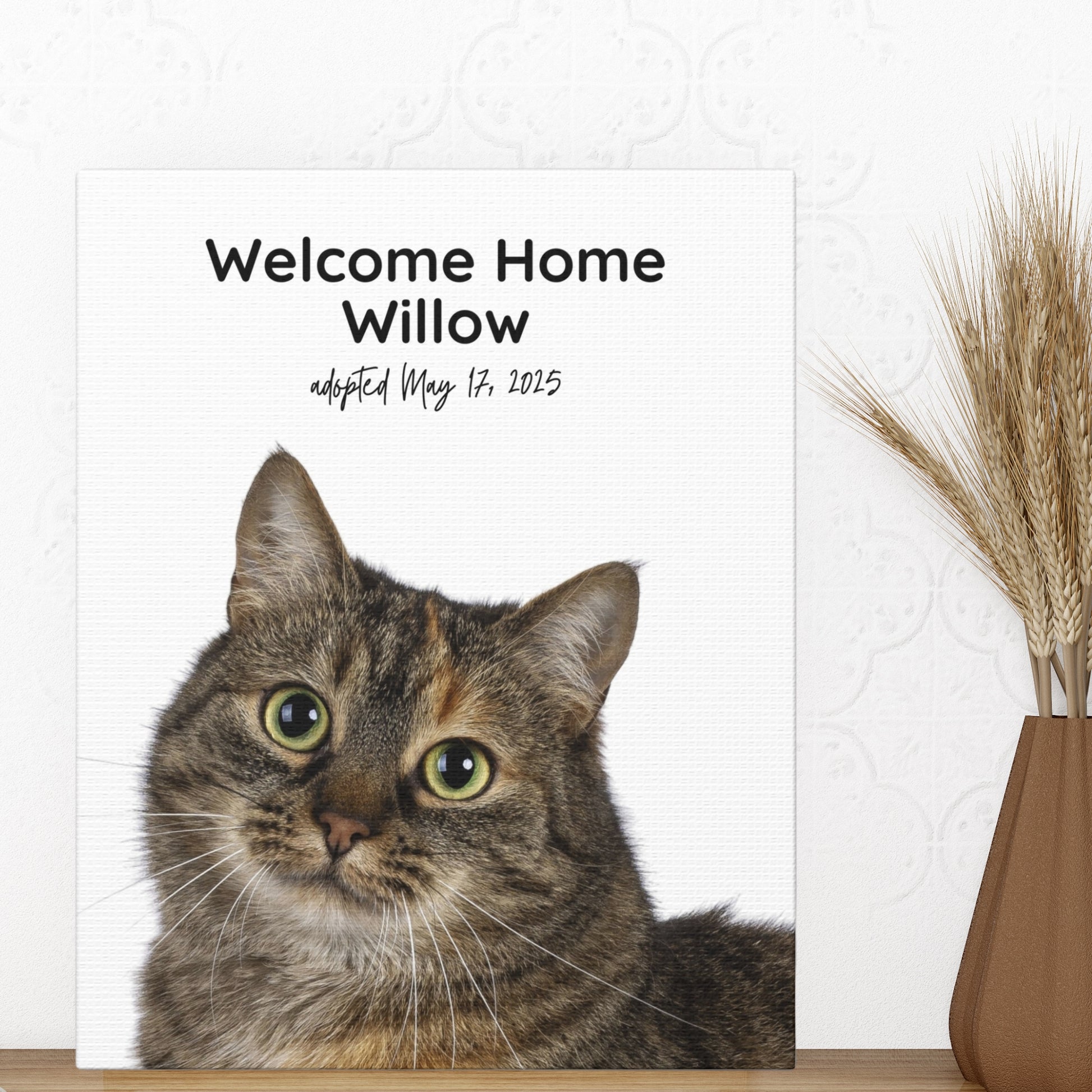 Personalized cat adoption canvas print featuring a tabby cat named Willow with “Welcome Home” text, displayed on a shelf with a vase of dried grass.