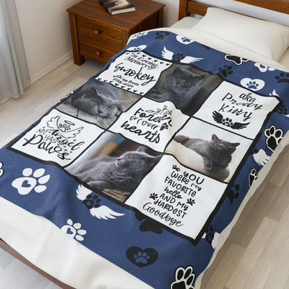 Personalized cat memorial blanket displayed on a bed, featuring photo collage, paw prints, angel wings, and remembrance quotes for a pet named Smokey