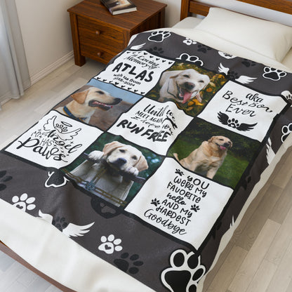 Custom dog memorial blanket with name, photos, and tribute quotes laid on a twin bed. Features paw prints and angel wings in charcoal gray, ideal for remembering a beloved pet with a personal touch.