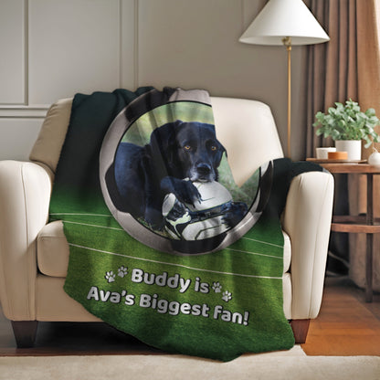Personalized soccer dog blanket with Buddy and “Ava’s Biggest Fan” message, draped on a white armchair in a cozy home setting