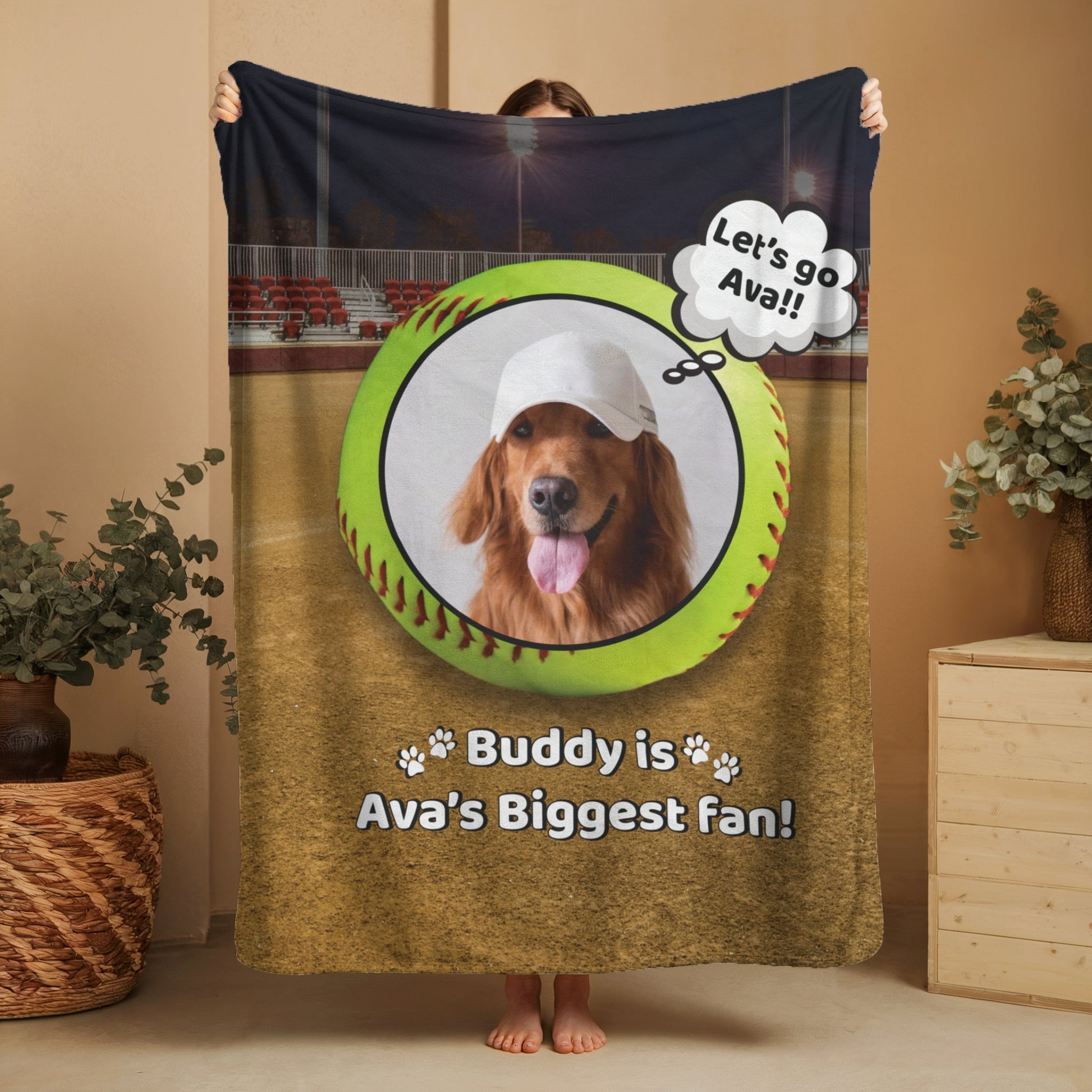 Personalized softball dog blanket featuring Buddy and “Buddy is Ava’s Biggest Fan” message, shown being held up in a cozy home setting to display full design and size