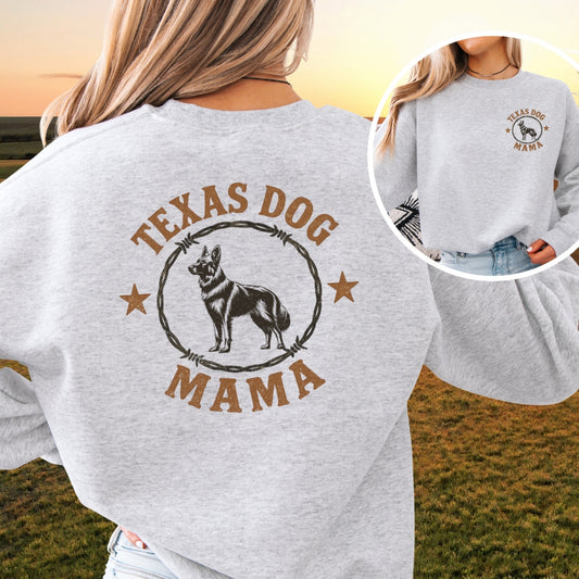 Woman wearing gray Texas Dog Mama German Shepherd sweatshirt with rustic barbed wire design, western outdoor background.
