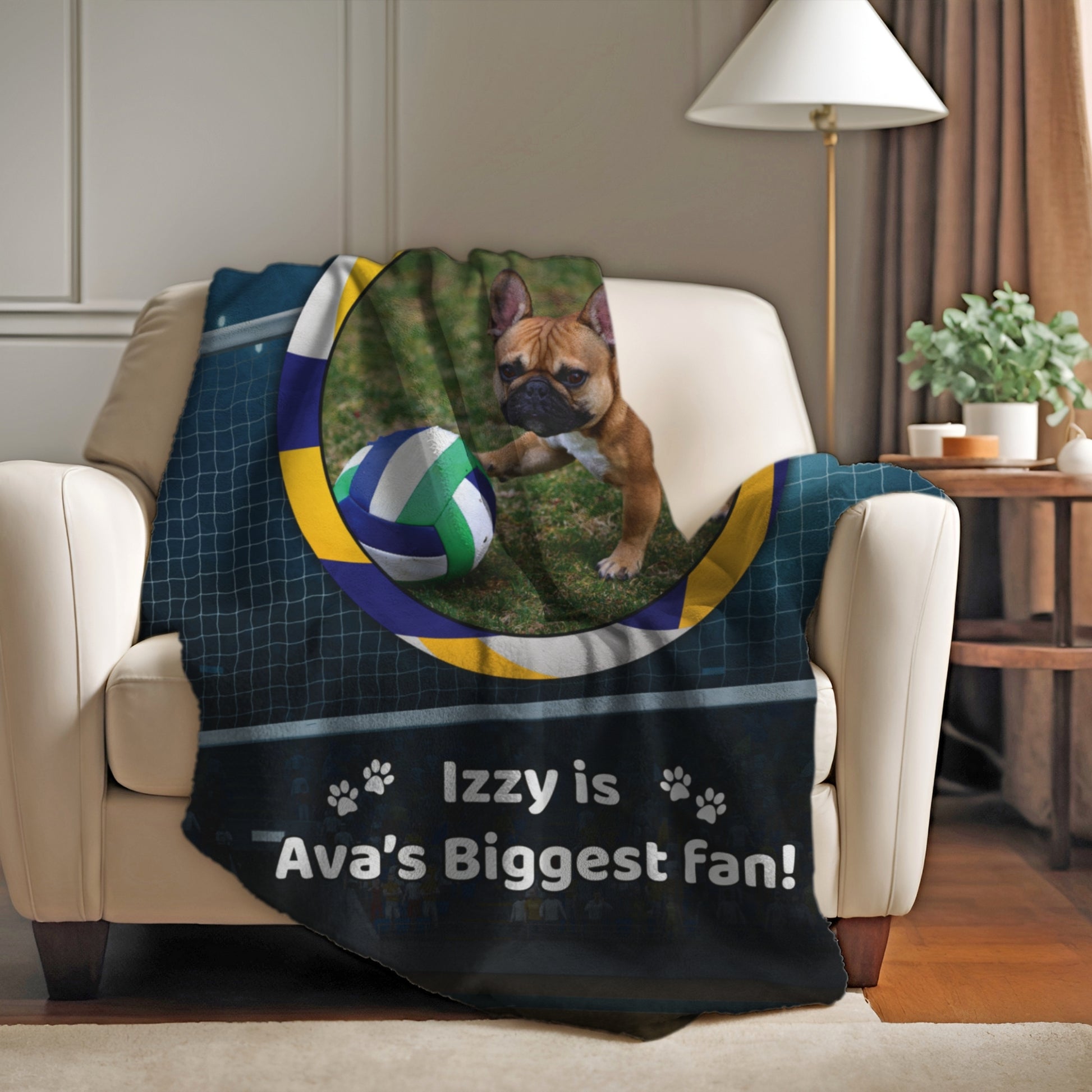 Custom volleyball blanket with Izzy the French Bulldog draped over a cozy armchair in a warm, softly lit living room.